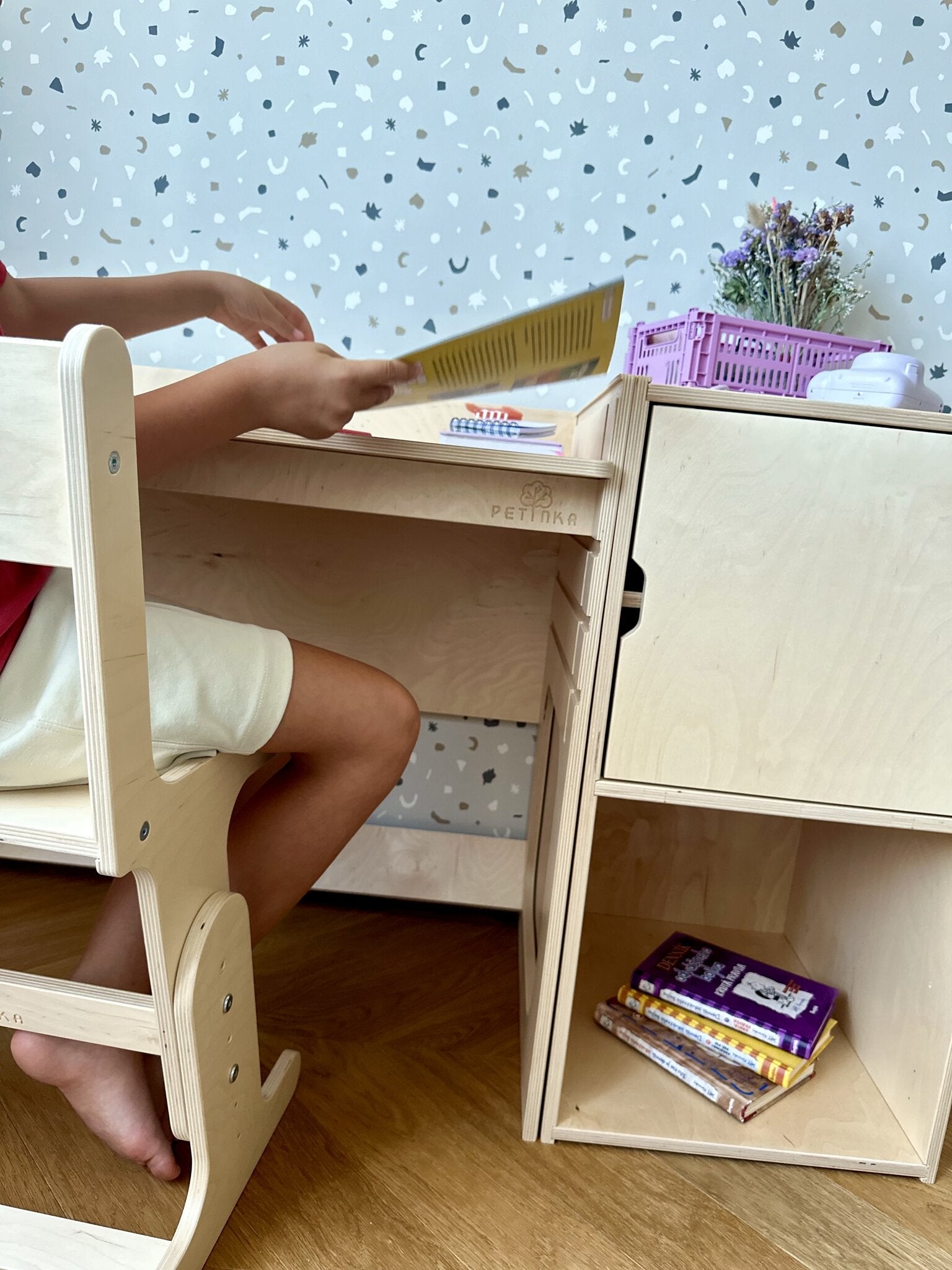 Child reading at the AGGIE desk on the AGGIE chair